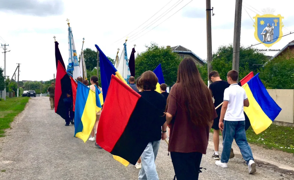 Люди з українськими прапорами йдуть вулицею