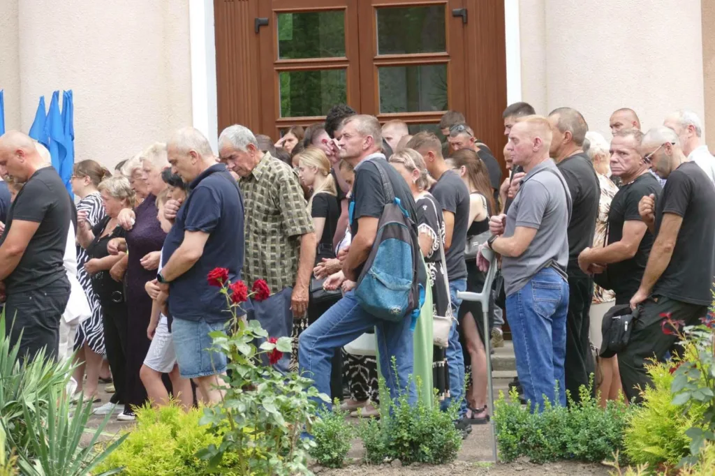 Люди стоять у черзі біля будівлі