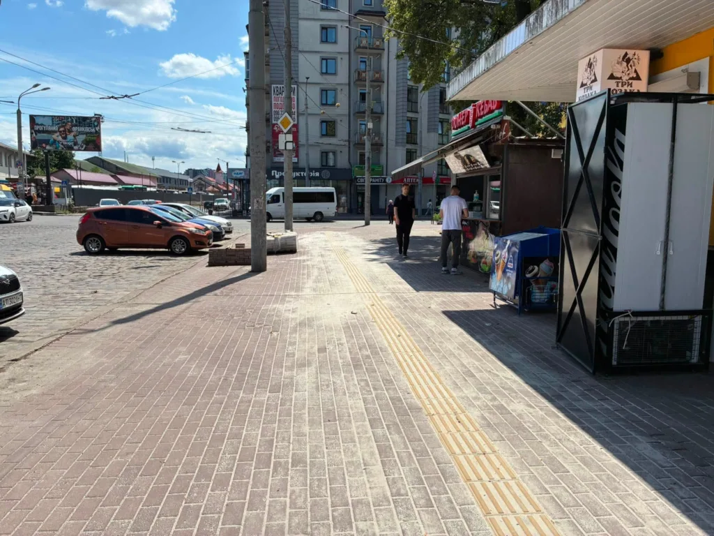 Міська вулиця з тротуаром і припаркованими авто