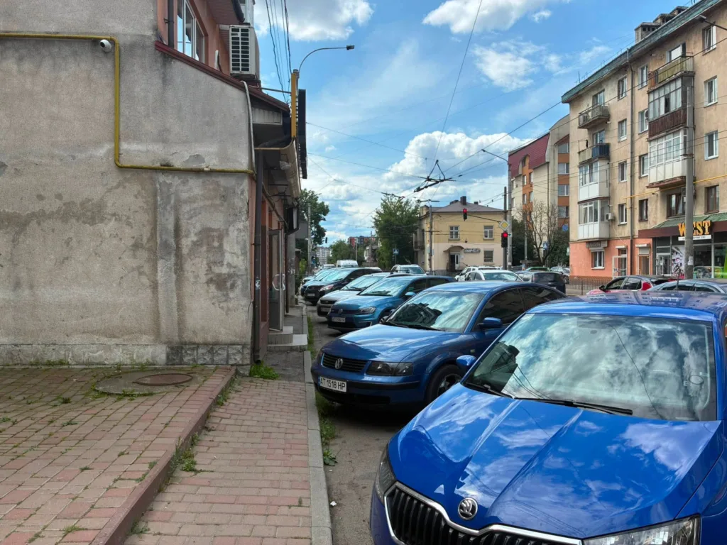 Вулиця з припаркованими автомобілями біля будинків