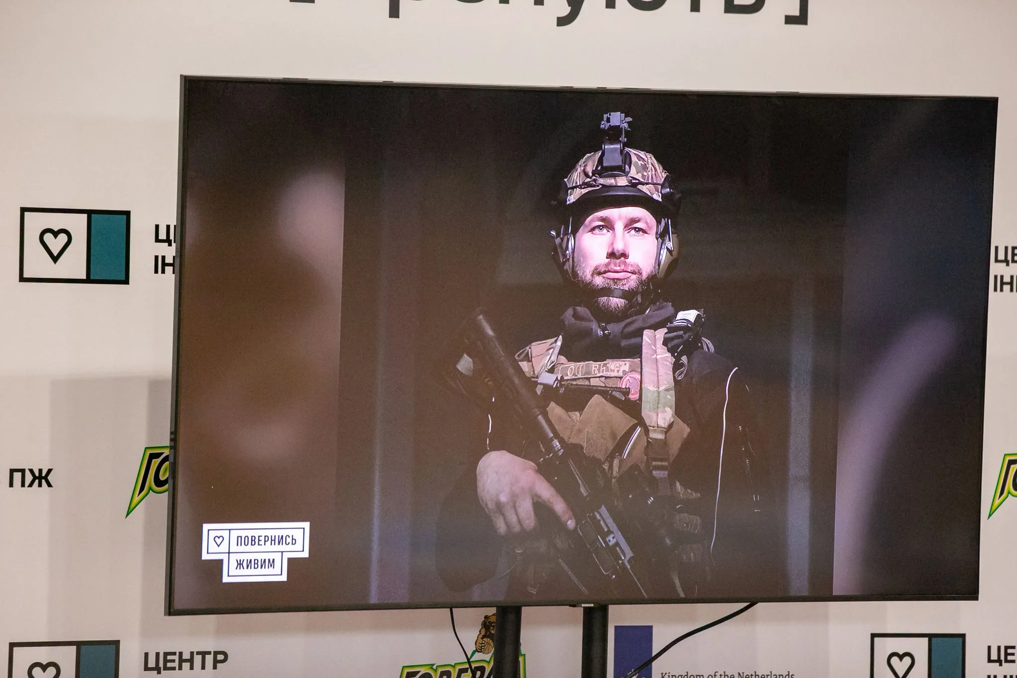 Військовий у бронежилеті тримає зброю