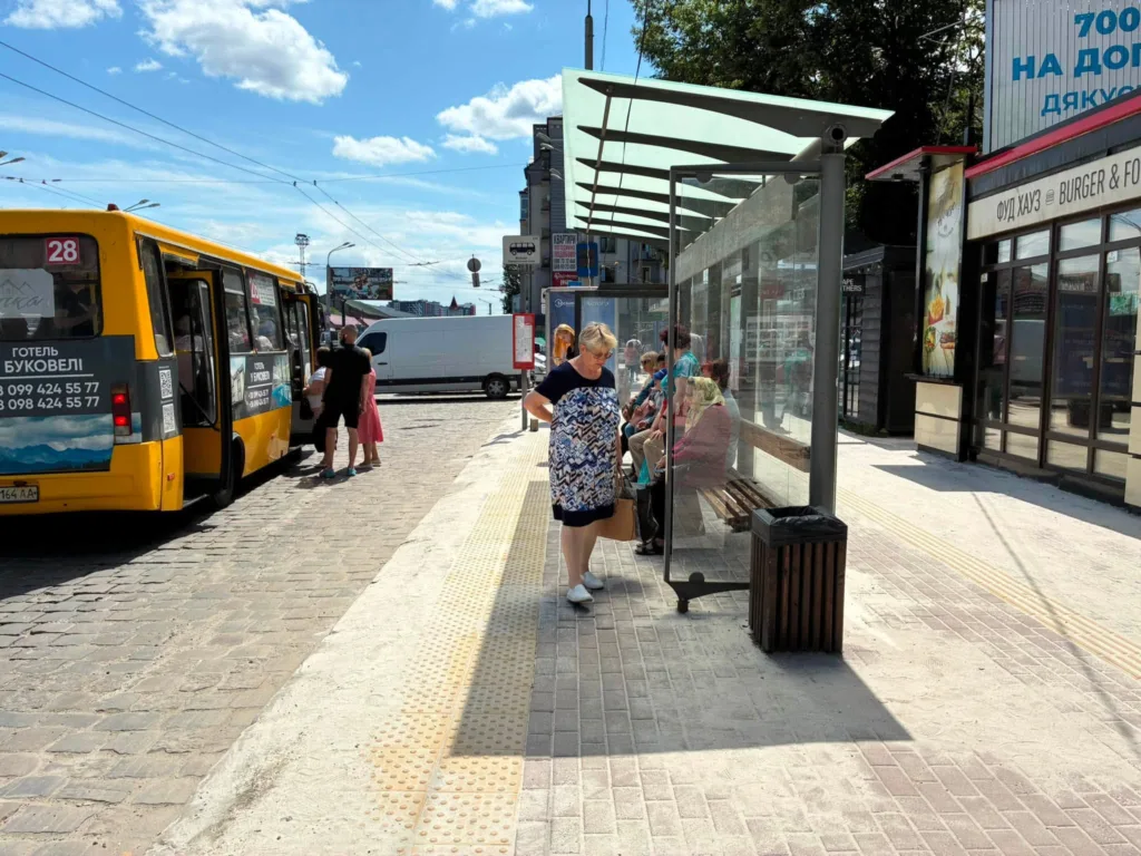 Люди чекають автобус на зупинці в місті