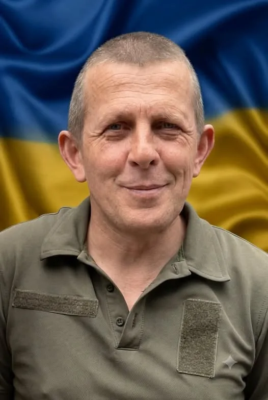 Чоловік у військовій формі на тлі прапора України
