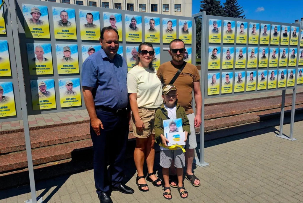 Сім'я біля стіни пам'яті загиблих військових