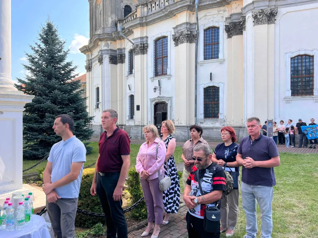 Люди моляться біля старовинної церкви на подвір’ї