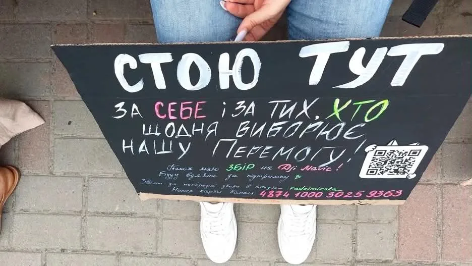 Плакат з написом українською мовою на тротуарі