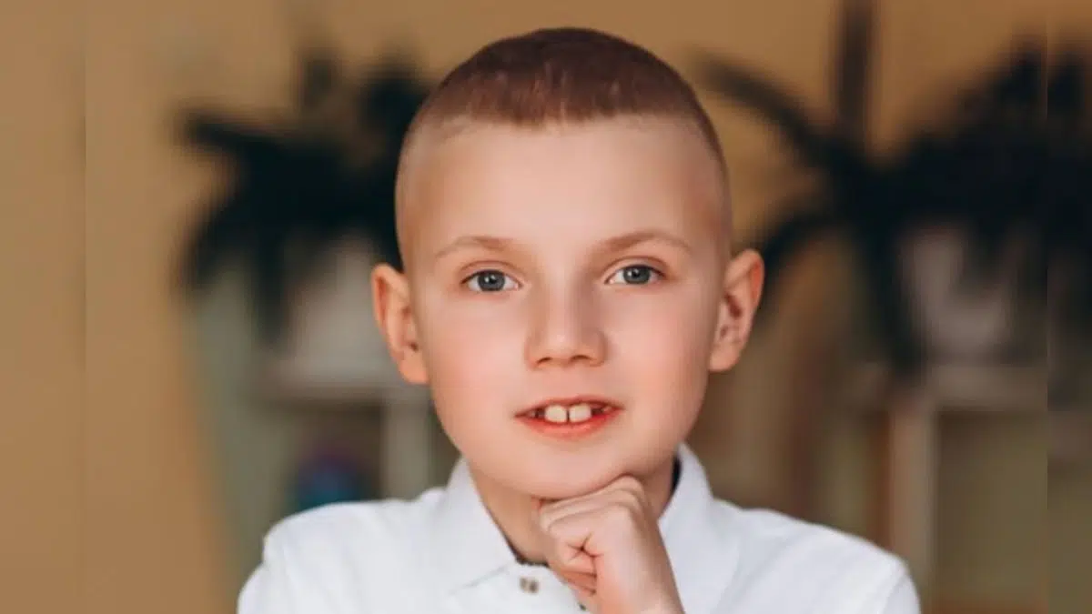 Хлопчик посміхається в білій сорочці