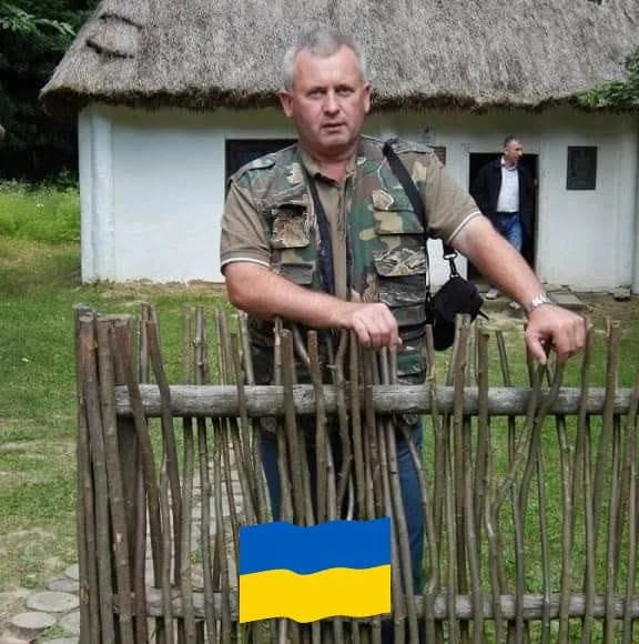 Чоловік біля старої української хати