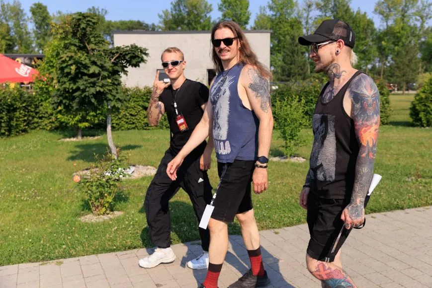 Троє чоловіків із татуюваннями прогулюються на вулиці