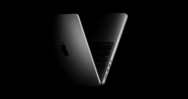Напівзакритий срібний ноутбук Apple на чорному тлі