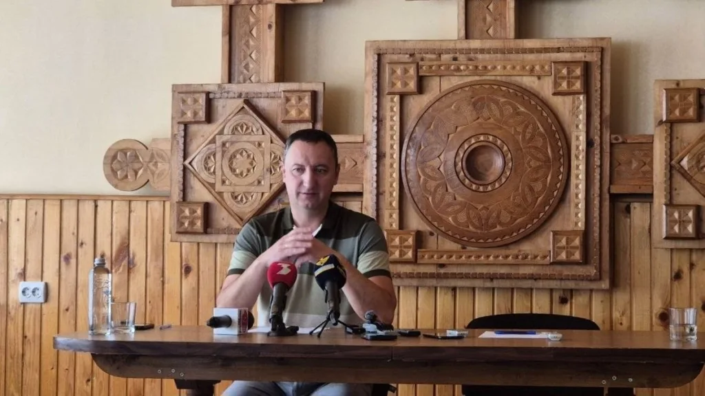Чоловік говорить на пресконференції перед мікрофонами