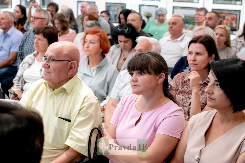 Люди слухають лекцію у залі