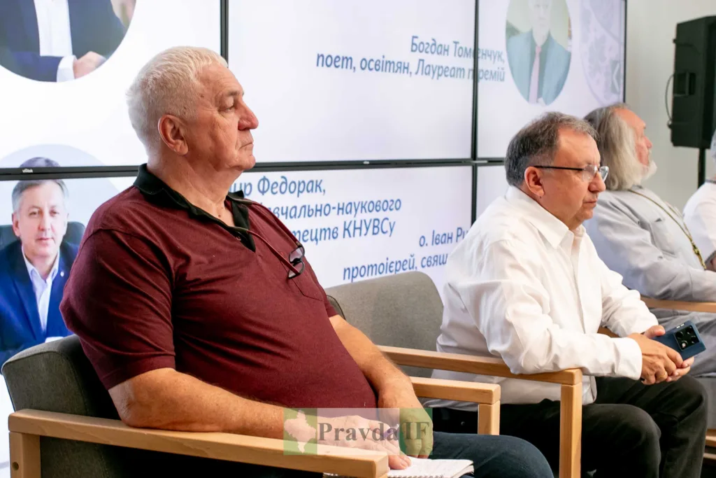 Чоловіки на конференції сидять у залі