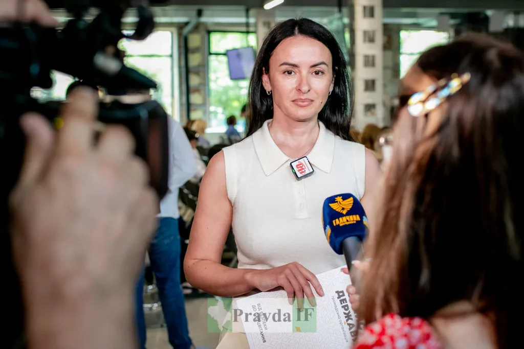 Жінка дає інтерв’ю перед телевізійними камерами