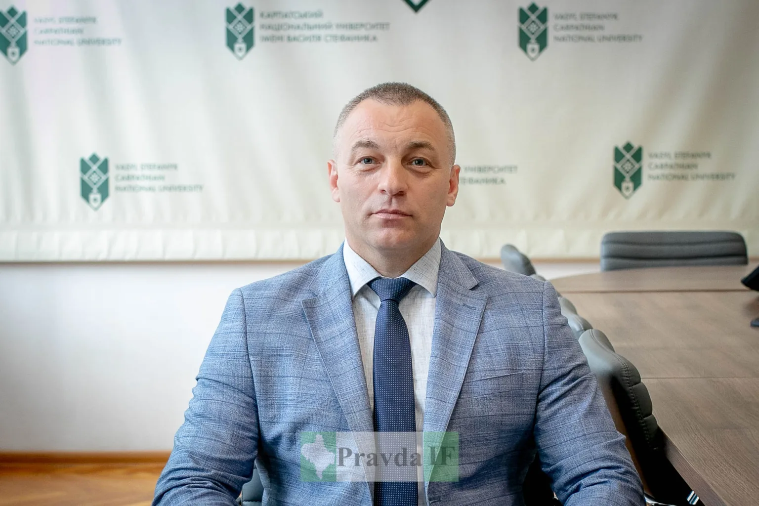 Чоловік у костюмі в університетській аудиторії