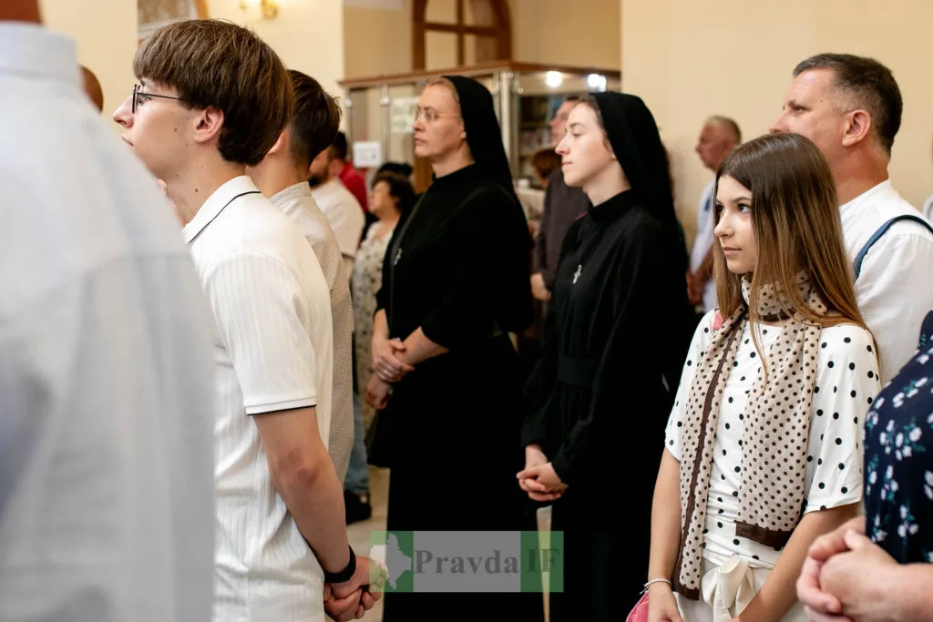 Люди стоять у церкві під час богослужіння