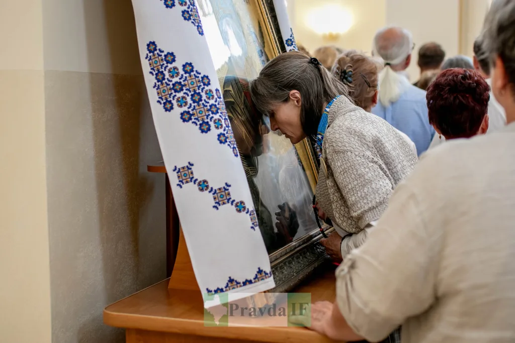 Жінка молиться перед іконою в церкві