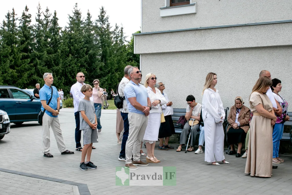 Люди стоять перед будівлею на вулиці