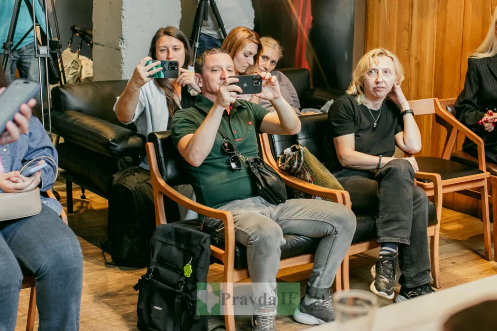 Люди фотографують подію у приміщенні