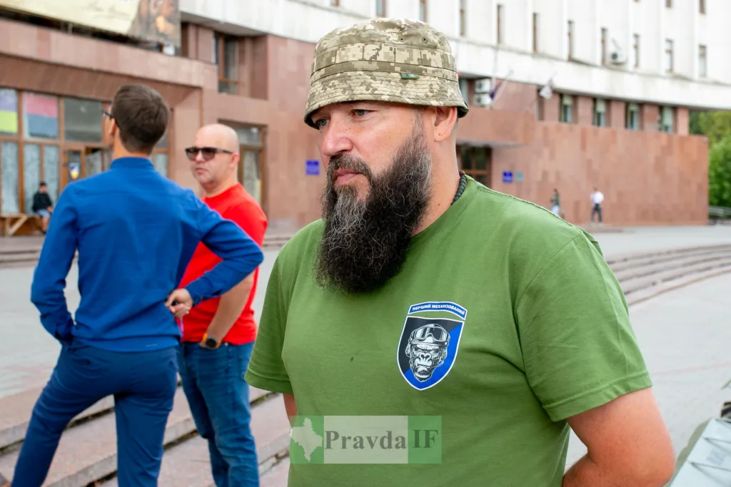 Чоловік у військовій формі стоїть на вулиці