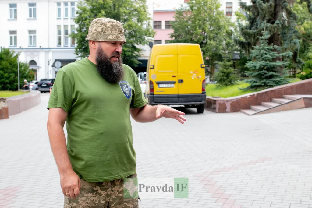 Військовий у формі стоїть на міській вулиці