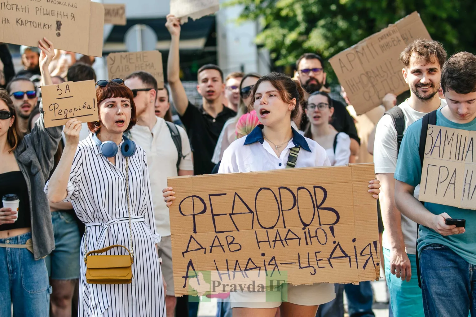 Люди на мітингу тримають картонні плакати