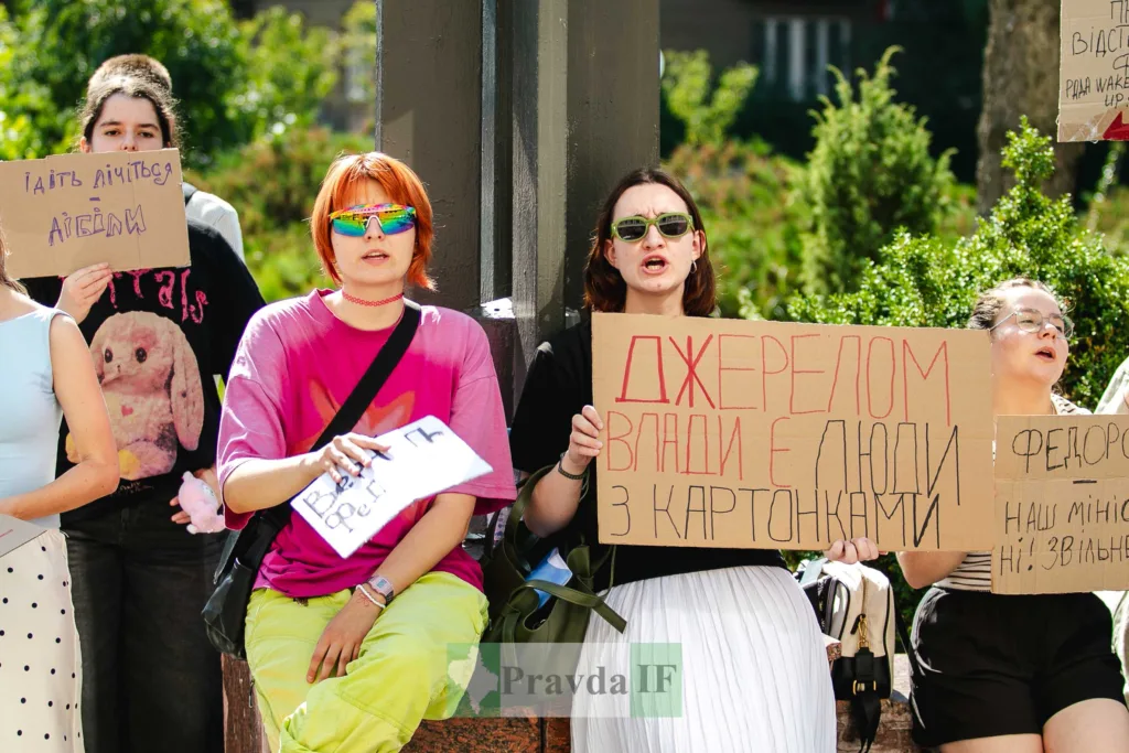 Люди тримають плакати на вуличному протесті