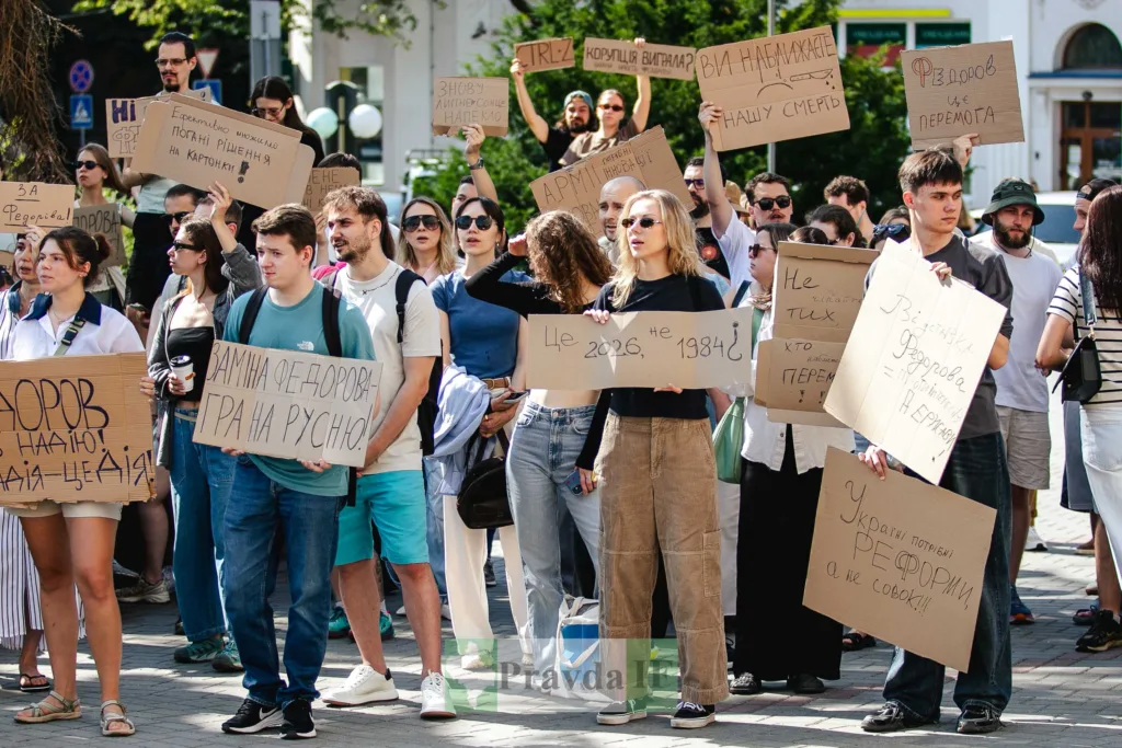 Люди протестують з плакатами на вулиці