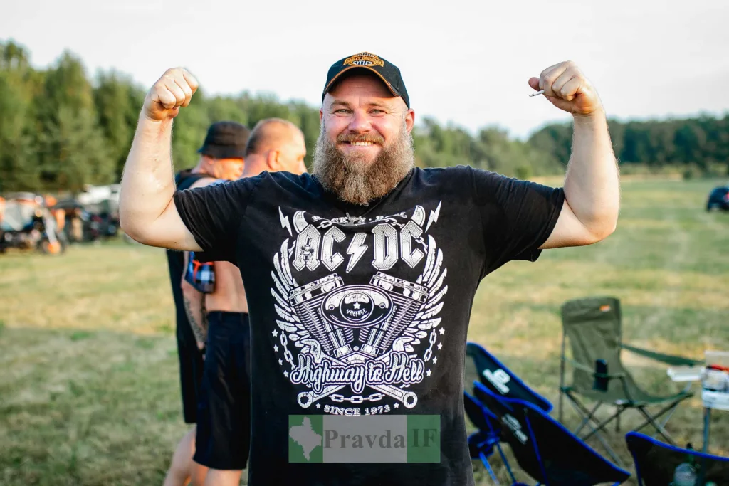 Чоловік на природі показує м’язи та усміхається