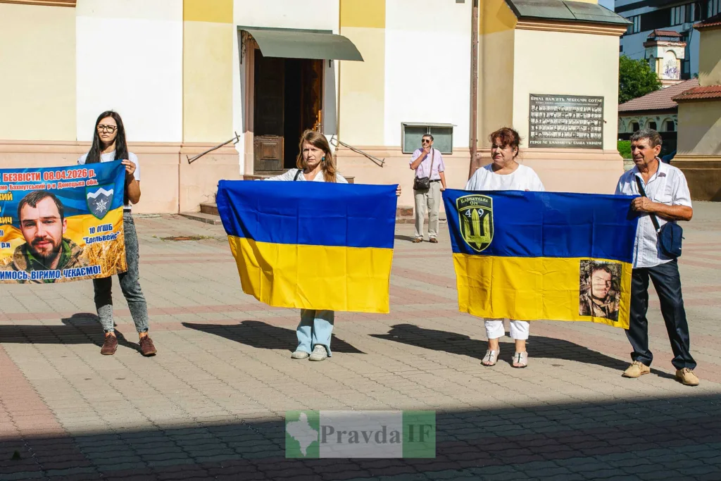 Люди тримають українські прапори на вулиці