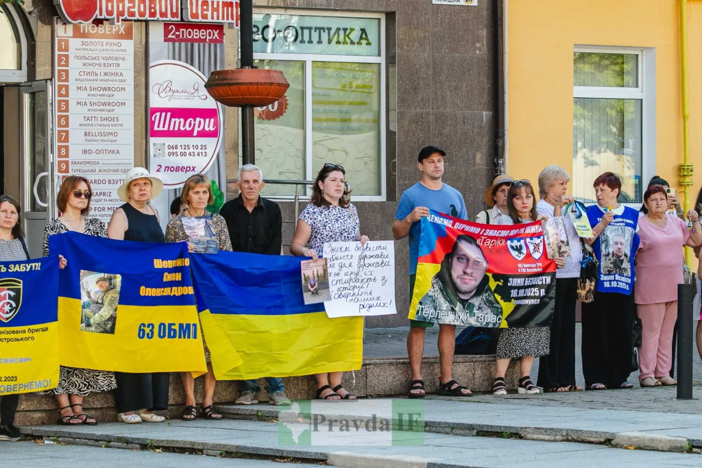 Люди тримають плакати й прапори на мирній акції