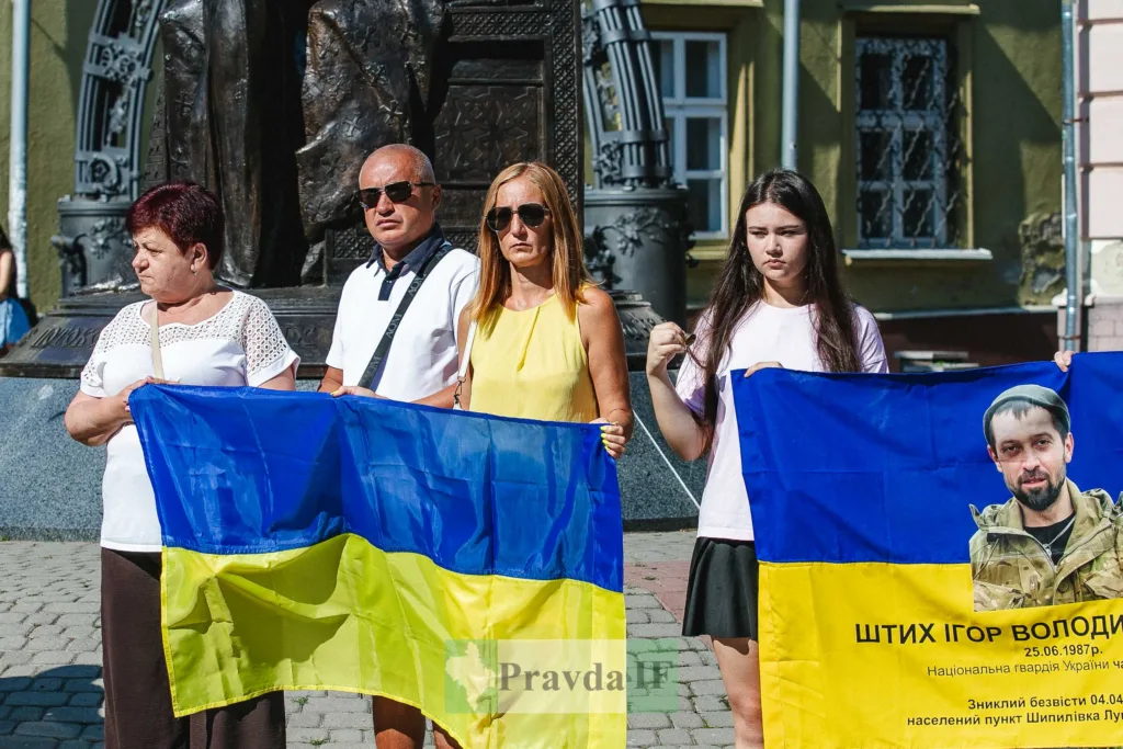 Люди тримають українські прапори на вулиці