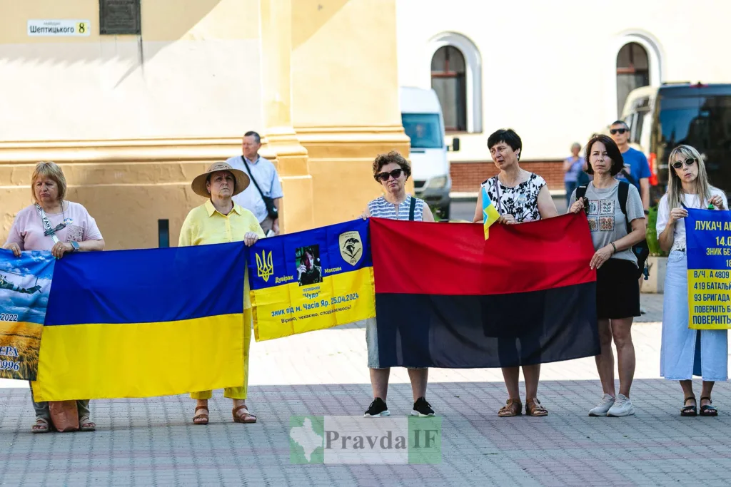 Люди тримають українські прапори на мирному мітингу