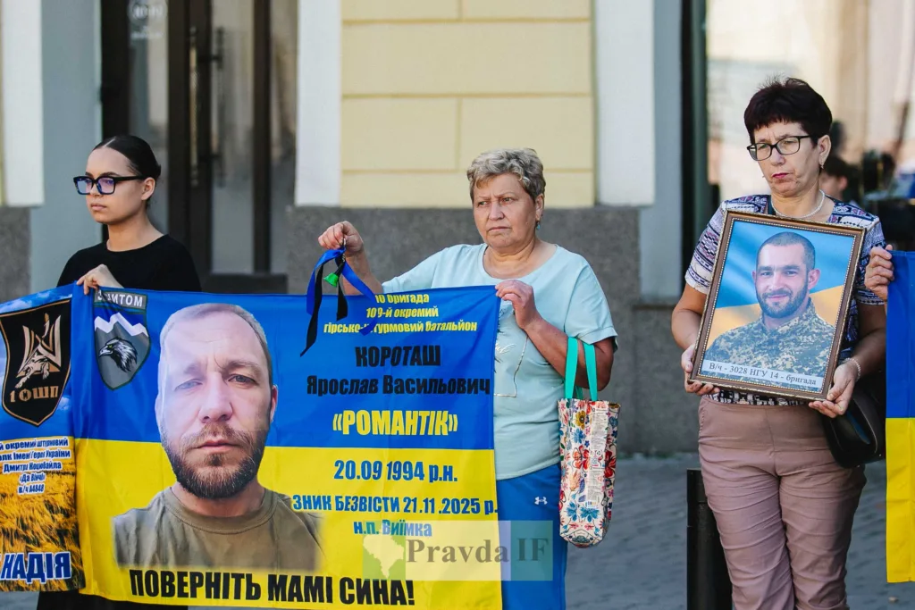 Жінки тримають плакати з фото зниклих військових