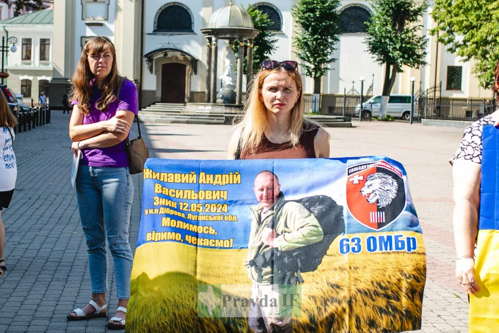 Жінки тримають банер з фото зниклого військового