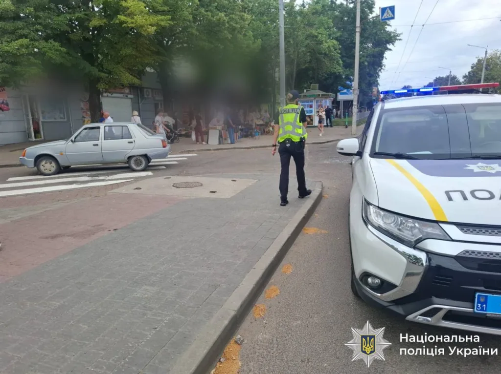 Поліцейський регулює рух біля пішохідного переходу