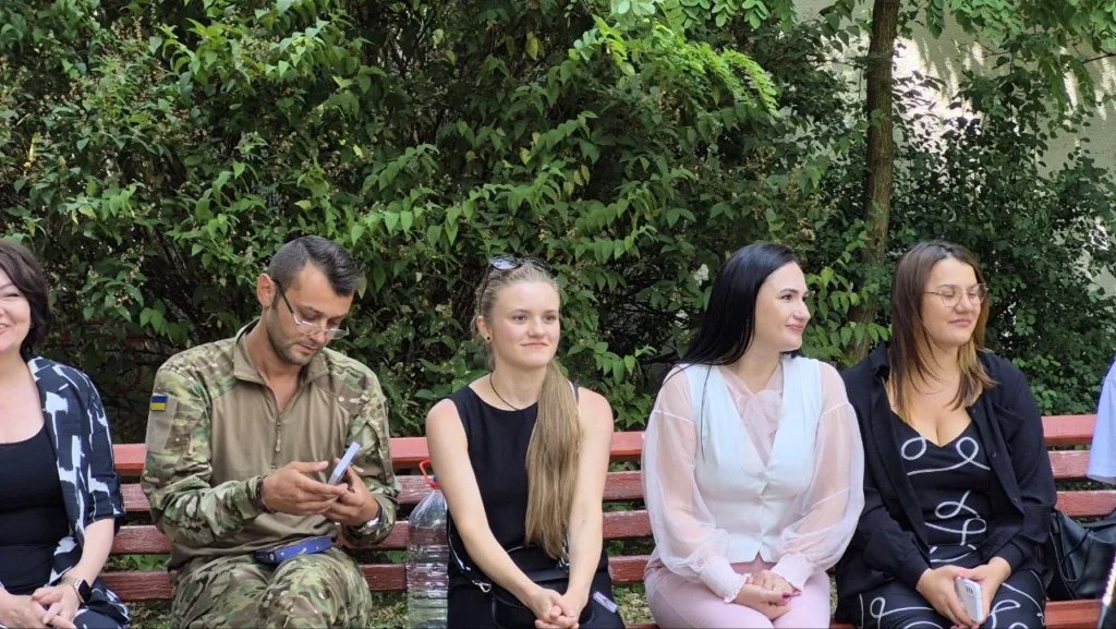 Люди сидять на лавці в парку