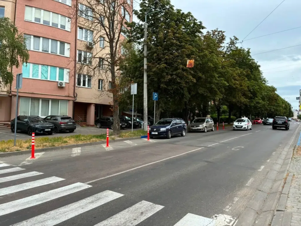 Міська вулиця з припаркованими автомобілями біля будинку