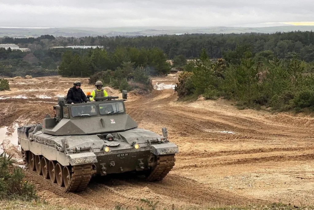 Військовий танк рухається по ґрунтовій дорозі