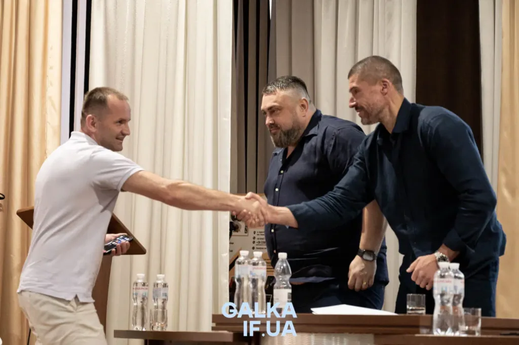 Троє чоловіків тиснуть руки на зустрічі