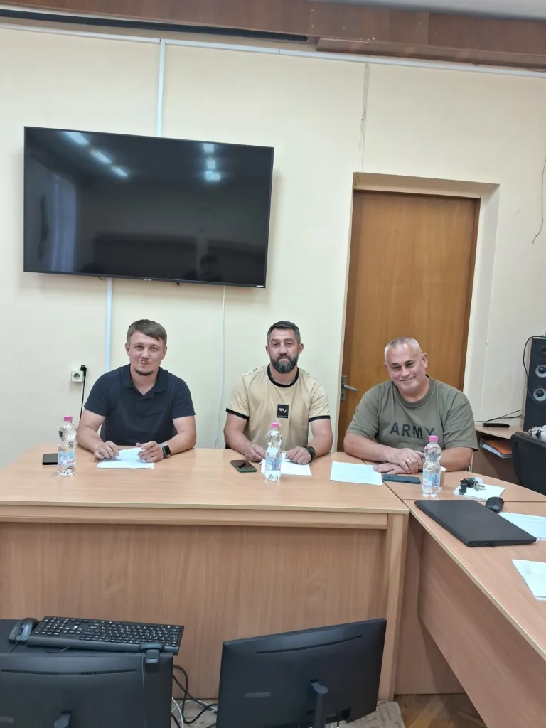 Троє чоловіків сидять за столом у офісі