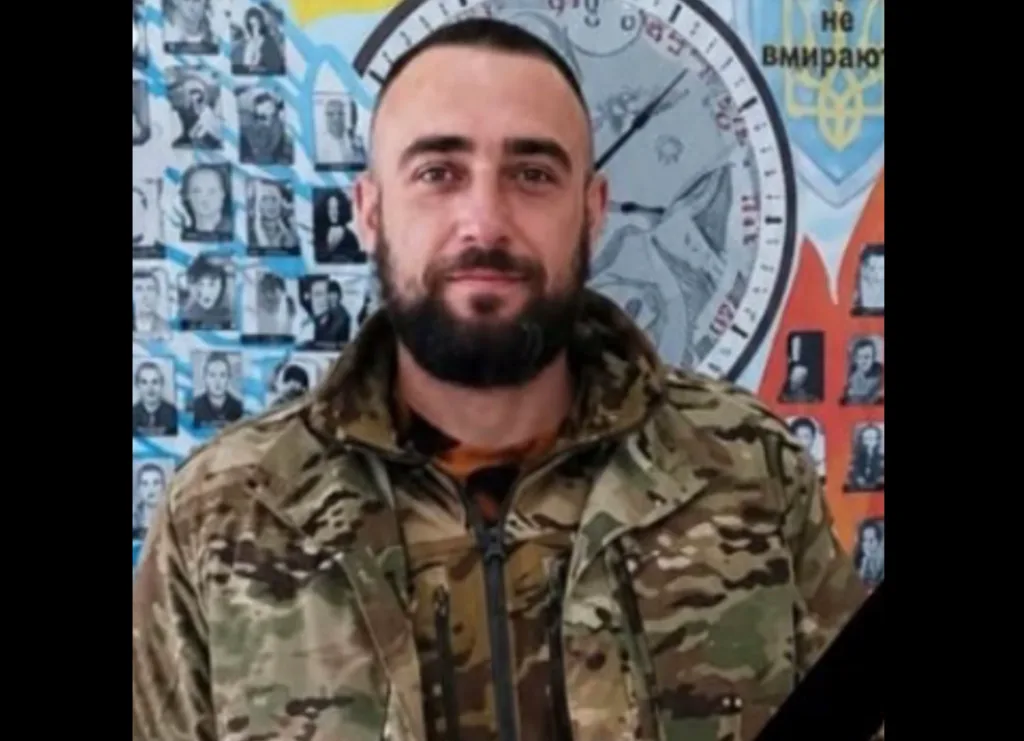 Військовий у камуфляжі перед пам’ятною стіною