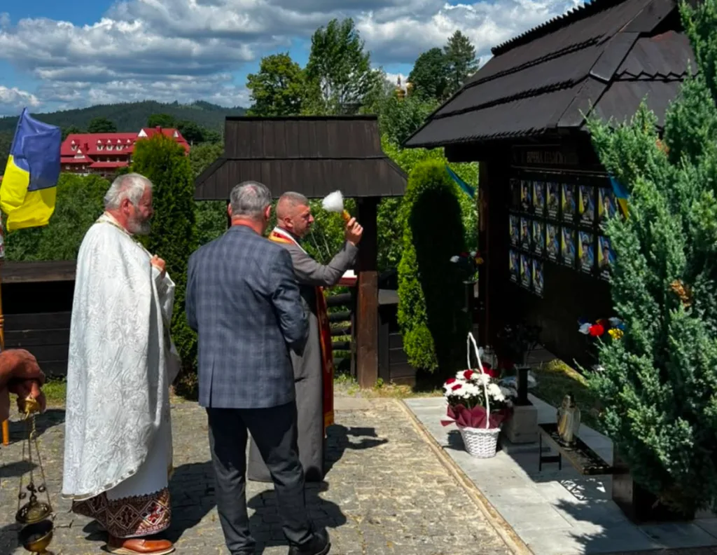Священник освячує меморіал українських героїв
