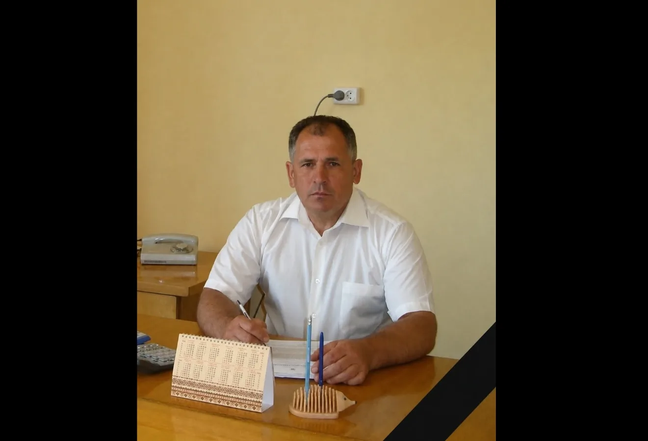 Чоловік у білому сидить за робочим столом