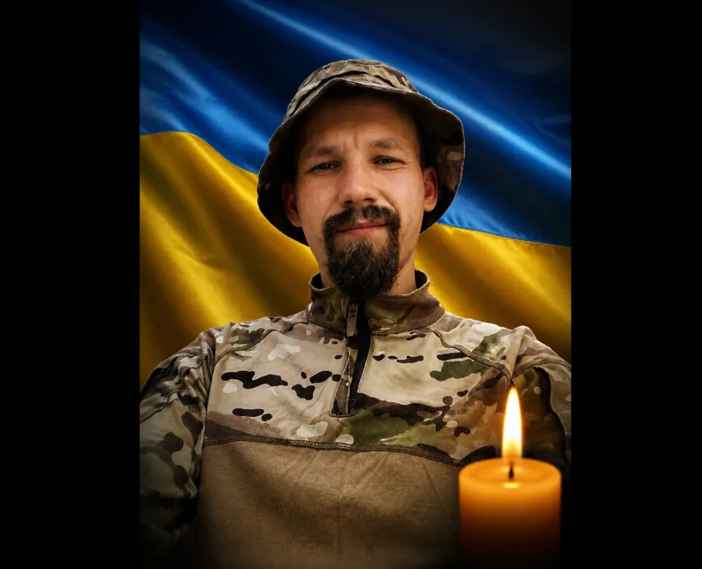 Військовий з свічкою на фоні прапора України