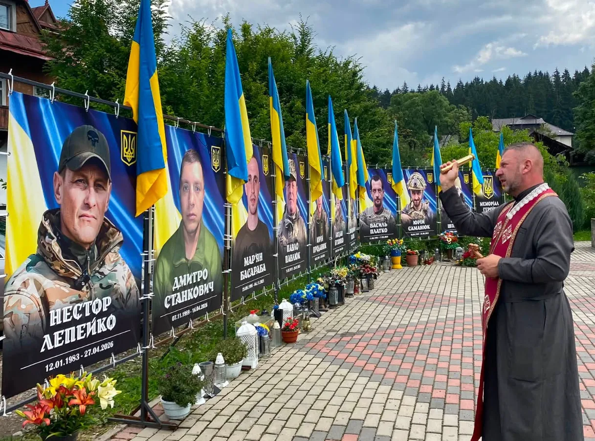 Священник молиться біля меморіалу загиблим героям України