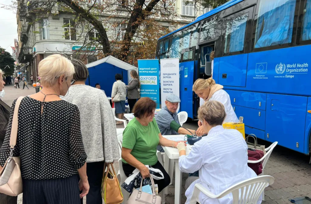 Медичне обстеження людей біля мобільного центру ВООЗ