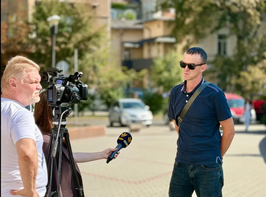 Чоловік дає інтерв’ю телевізійній знімальній групі