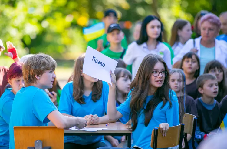 Школярка тримає картку «Право» під час заходу