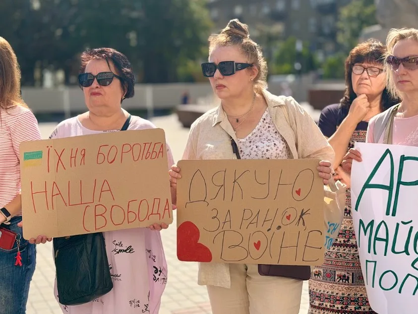 Жінки на мирній акції з плакатами підтримки України